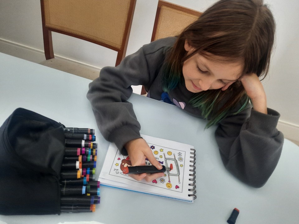 Criança mostrando desenho bíblico finalizado